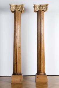 A pair of impressive ionic columns. Fluted pine with gilt finish capital. Each 229cm high.