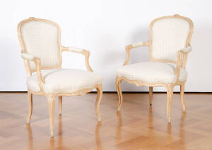 A pair of Louis style armchairs with carved timber frame bases, checked upholstery.&nbsp;