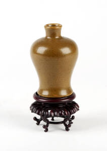 A Chinese tea dust glaze miniature baluster vase, Qing dynasty, 11cm high, wood stand
