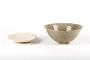 A large celadon glazed deep circular bowl, carved with stylised flowers,&nbsp;20cm diameter and one other glazed bowl, 15cm diameter