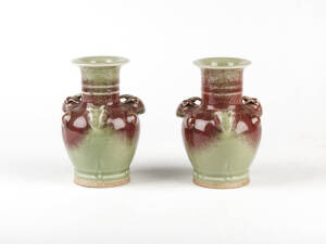 A pair of sang-de-boeuf and celadon glazed vases with ram's heads handles, 13cm high