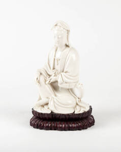 A Blanc-de-Chine seated figure of Guanyin, wood stand, 20cm high