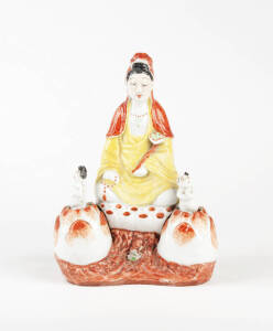 A painted porcelain figure of Guanyin with tow rocking attendants