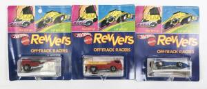 HOTWHEELS: 1973 group of Redline ‘Revvers’ including Towin’ Terror (6999) – Enamel Red with Plastic Yellow Crane; and, Haulin’ Horses (6988) – Enamel Red; And, Draggin’ Dagger (6985) - Enamel Blue. All mint and unopened in original rectangular blue bliste