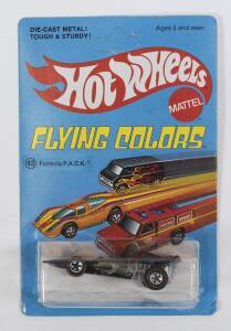 HOTWHEELS: 1976 Redline ‘Flying Colors’ Formula P.A.C.K (9037) –Black with Yellow & Red P.A.C.K. Mint and unopened in original unpunched rectangular light blue blister pack.