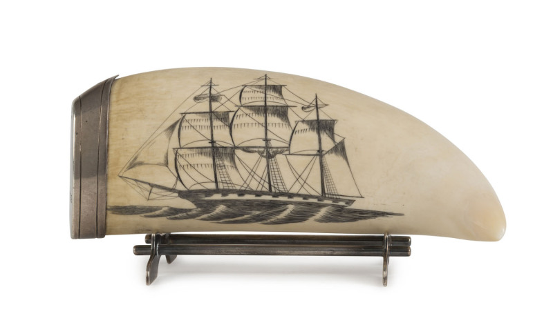 A scrimshaw whale's tooth with silver mount and stand, 20th century