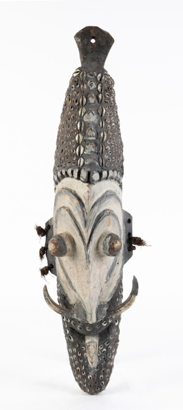 A tribal mask, carved wood, shell, tusk and fibre with natural earth pigments, Wewak, Papua New Guinea, mid 20th century