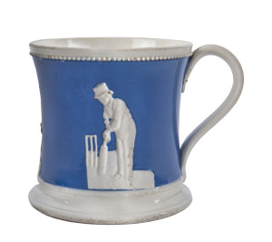 c.1850 Staffordshire Cricket Mug with a blue glaze field, raised decorations, a beaded rim with raised figures of Thomas Box, Filler Pilch and William Clarke, fine condition. 10cm high.