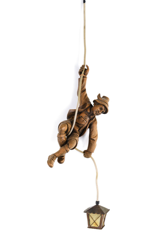 A Black Forest hanging light in the form of a mountaineer, carved wood, copper and celluloid, German, early 20th century