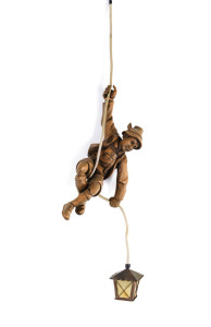 A Black Forest hanging light in the form of a mountaineer, carved wood, copper and celluloid, German, early 20th century