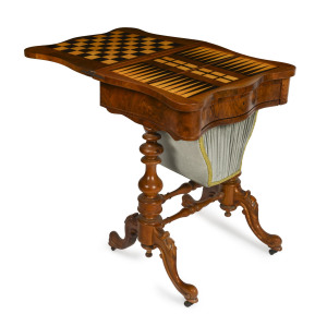 A Victorian games/sewing table, burr walnut and silk, English circa 1875, foldover top with chess, backgammon and cribbage board inlaid top, drawer fitted with compartments and full of 19th and 20th century sewing accoutrements