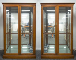 A two-sectional four door display cabinet, timber and glass, electrified, late 20th century