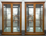 A two-sectional four door display cabinet, timber and glass, electrified, late 20th century