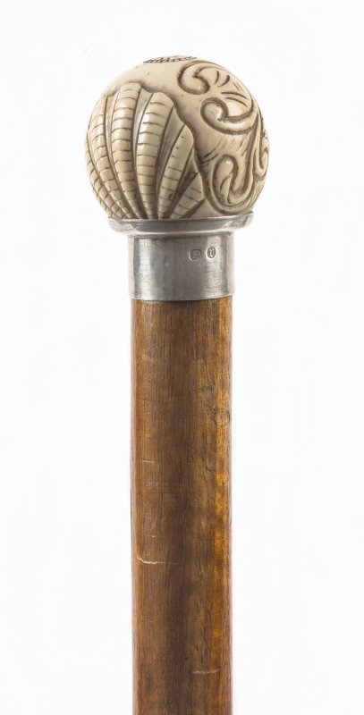 A walking stick with carved ivory handle, silver collar and blackwood shaft, 19th century