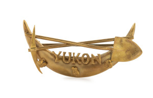 A Canadian "YUKON" goldfields brooch with pick and shovel over crescent adorned with nuggets, 19th century