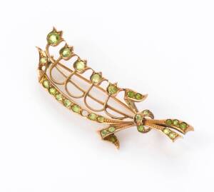 A peridot brooch, of lily of the valley design. Rose gold. 4.75 grams, 48mm long. Please note two stones deficient.