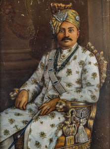 THE CORONATION PORTRAIT OF "RANJI" - Colonel H.H. Shri Sir Ranjitsinhji Vibhaji, Maharaja Jam Saheb of Nawanagar K.C.S.I. in his coronation robes and jewellery,three-quarter length seated in a gilded throne chair with lion finial arms. Ranji wears a cream silk diamond-buttoned sherwani tunic with a pattern of gold and green flowers. He holds a jewelled sword tulwar (the traditional Rajput weapon), a diamond peacock sarpech in his gold and green turban.
