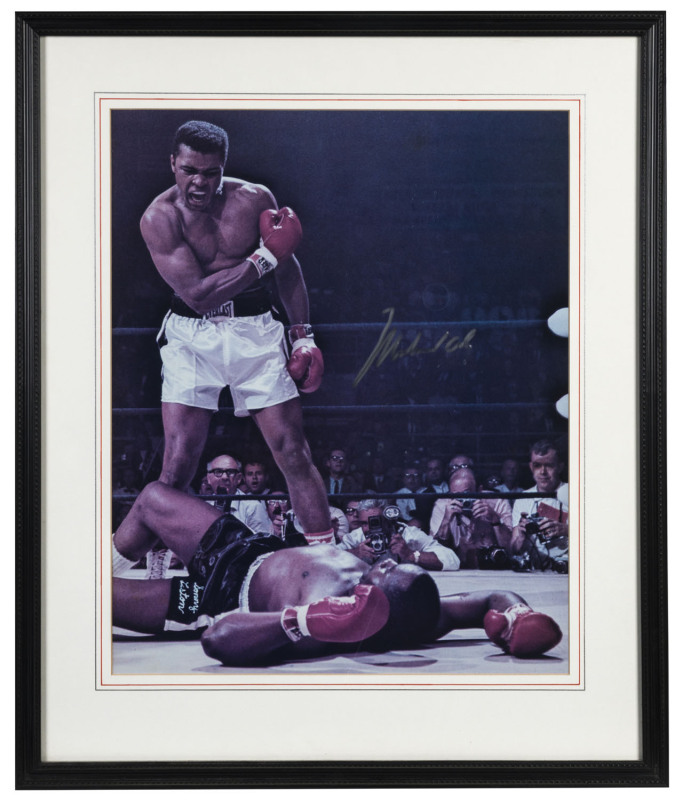 MUHAMMAD ALI signed photograph; the iconic 1965 image of Ali rampant over Sonny Liston sprawled on the mat below him. Framed & glazed, with Field of Dreams Certificate of Authenticity. Overall 64 x 54cm.