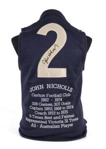 CARLTON: John Nicholls original signature on the "No.2" on the back of a short-sleeved Carlton jumper. Big John's statistics 1957-74 embroidered below the number.