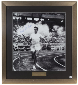 RON CLARKE, signature on large photograph of Clarke carrying the Olympic Torch into the MCG, window mounted, framed and glazed, overall 71x78cm.