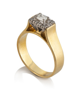 An 18ct gold ring set with an emerald cut diamond surrounded by 10 brilliant cut diamonds set in platinum,