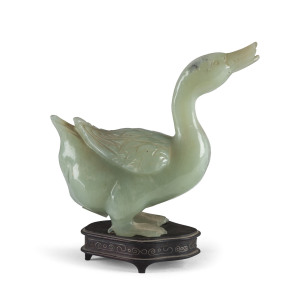 A Chinese carved celadon jade duck on wooden stand with silver inlay, early 20th century,