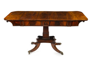 A Regency drop-side sofa table, flame mahogany with ebony stringing and brass casters, English, circa 1820