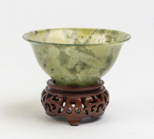 A spinach jade bowl on carved wooden stand, 20th century