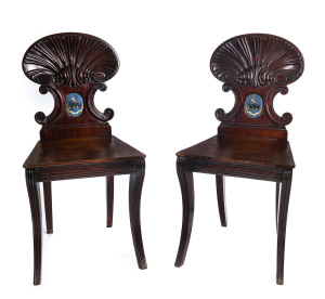 A pair of English Regency hall chairs, finely carved mahogany with handpainted panel crests, circa 1810,