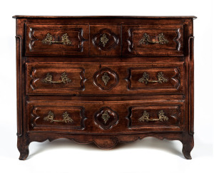 An early 18th century French walnut commode with serpentine front, unusual drawer configuration with the top bank divided into three drawers,