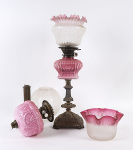 Two antique oil lamps with glass fonts and shades, plus an original extra ruby acid etched shade, 19th century,