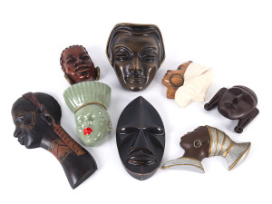 Group of eight assorted Nubian female face plaques, ceramic and carved wood, 20th century,