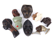 Group of eight assorted Nubian female face plaques, ceramic and carved wood, 20th century,