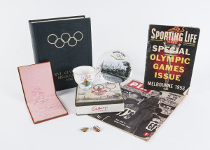An interesting accumulation including "The Official Report" 760pp; 2 official "VISITOR" lapel badges by K.G. Luke; a souvenir cup and saucer; a Melbourne Olympics chocolate tin by Cadbury's; an autograph book containing many autographs (mainly internation