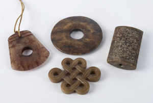 Three Chinese carved jade pendants and a pi disc, ​the disc 6cm diameter