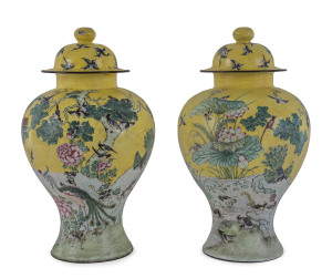A rare pair of Chinese bronze and enamel vases decorated with scenes of birds and peacocks and lotus, flowering peony and iris on an imperial yellow ground, the domed covers with additional birds in flight, the bases with blue dragon roundels. 19th centur