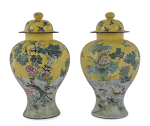 A rare pair of Chinese bronze and enamel vases decorated with scenes of birds and peacocks and lotus, flowering peony and iris on an imperial yellow ground, the domed covers with additional birds in flight, the bases with blue dragon roundels. 19th century,34cm high (with lids).