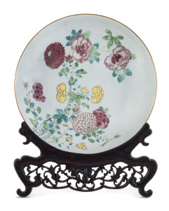 A Chinese famille rose porcelain dish on carved stand, 18th century, 22cm diameter