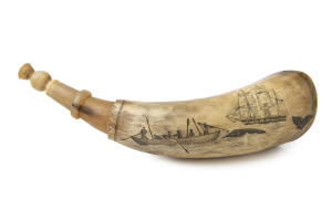 A scrimshaw powder horn with whaling scene engraved "Sperm Whaling, So Be Cheery My Lads, Let Your Hearts Never Fail, While The Bold Harpooner Is A-striking The Whale", 24.5cm long