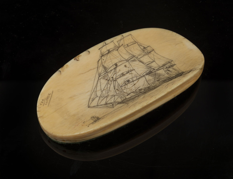 A scrimshaw whalebone paperweight with tallship titled "Tea Clipper", 19th century, ​13.5cm across
