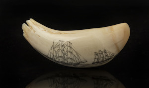 A scrimshaw whale's tooth with tallships, monogrammed "J.F.C.", 11cm long