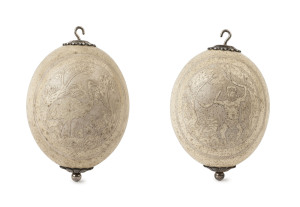 A pair of ostrich egg hanging ornaments, carved with Aborigine and emu, 19th century, 18cm high