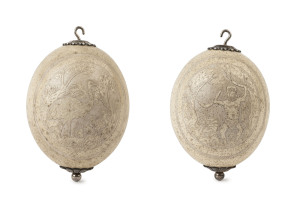 A pair of ostrich egg hanging ornaments, carved with Aborigine and emu, 19th century, ​18cm high