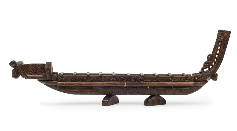 A Maori miniature canoe, carved hardwood, paua shell and fibre, New Zealand, 20th century 99cm long