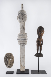 A carved mask and two carved figures, wood and shell with pigment finish, Papua New Guinea, early to mid 20th century, the tallest 78cm high