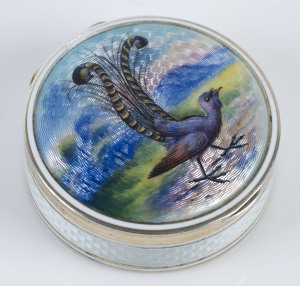 A sterling silver pill box with enamel lyrebird decoration, circa 1900, stamped "925, S & Co. n" with triangle mark, 4.5cm diameter