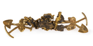 An unusual gold miner's brooch with gold ore and nuggets with crossed pick and shovel at each end, 19th century, stamped "15ct", 6cm long, 10.5 grams total.