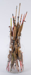 A collection of antique and vintage cork fishing floats in a glass jar, 19th and 20th century, the largest 46cm high