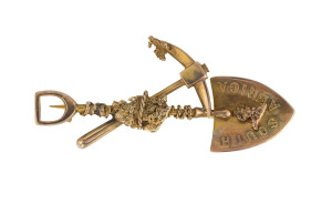 A gold miner's brooch with pick, shovel, rope and nuggets