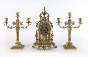 A German gilt metal clock and pair of three branch candelabra, mid 20th century, the clock 42cm high
